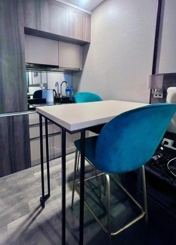バトゥミにあるRainbow residenceのキッチン(テーブル、青い椅子2脚付)