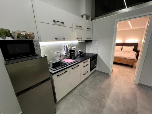 cocina con fregadero, nevera y cama en Mandouki Urban Stay, en Corfú