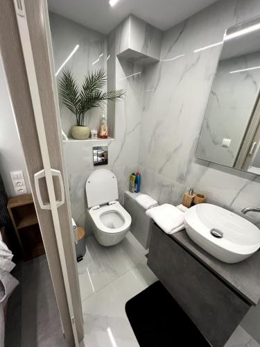 a bathroom with a white toilet and a sink at Mandouki Urban Stay in Corfu