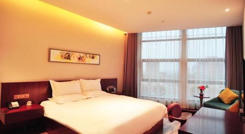 a hotel room with a bed and a large window at Hangzhou Berman Hotel in Hangzhou