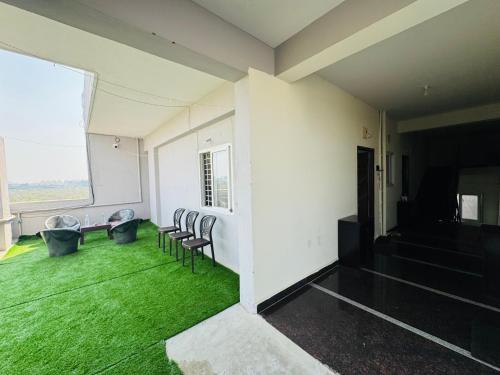 a room with chairs and a large window with green grass at Penthouse Escape 1BHK Park View Flat in Kondapur in Hyderabad