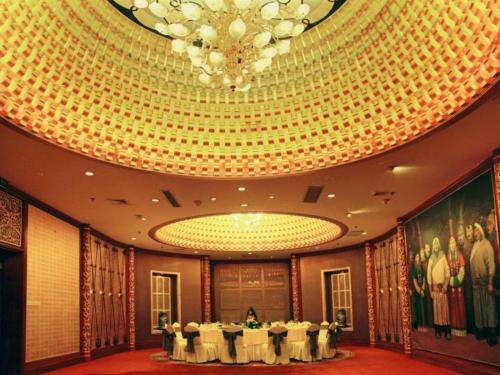 a banquet hall with white tables and a chandelier at Hohhot Inner Mongolia Hotel in Hohhot