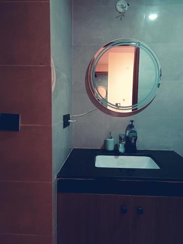 a bathroom with a sink and a mirror at CozyCity Retreat 2 Studio Apartment with Kitchen Perfect for longer stays in Lucknow