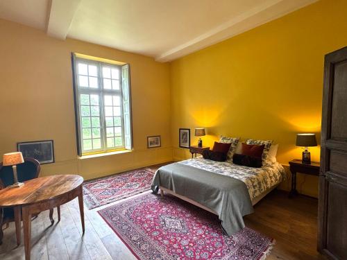 une chambre avec un lit, une table et une fenêtre dans l'établissement Le château de Grisy -13p et sa Ferme -9p, Piscine, à Vendeuvre