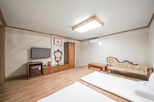 昌原市にあるChangwon Olympic Hotelのソファとテレビのあるリビングルーム