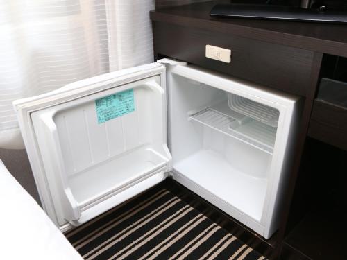 an empty refrigerator with its door open in a kitchen at APA Hotel Tottori Ekimae in Tottori