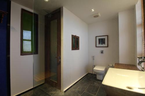 a bathroom with a shower and a toilet and a sink at The Sky Imperial Aarivaa Luxury Stays in Rajkot