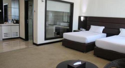 a hotel room with two beds and a bathroom at The BCC Hotel & Residence in Nagoya