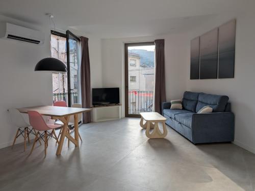 a living room with a blue couch and a table at Ca l'Emília, hasta 6 pers, Monistrol de Montserrat in Monistrol