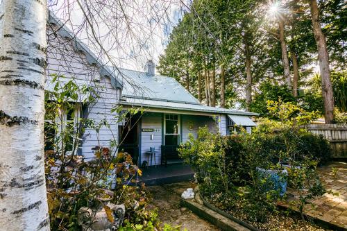 a white house with a porch in a yard at Chinoiserie - Blue Mountains Boho Luxe in Katoomba