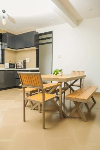 Un comedor con mesa y sillas de madera. en Stylish & Secure 2BR with free Parking & Wi-Fi Included, en Kajansi