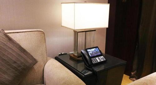 a phone sitting on a table next to a couch at Xi'an Airport Hotel in Xi'an