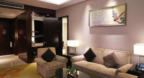 a living room with two chairs and a couch at Xi'an Airport Hotel in Xi'an