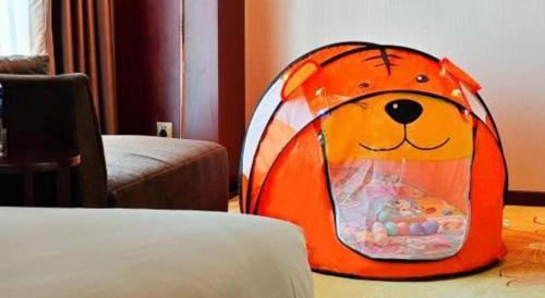 an orange dog tent sitting on the floor in a room at Xi'an Airport Hotel in Xi'an