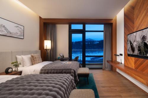 Postel nebo postele na pokoji v ubytování Oakwood Suites Chongli