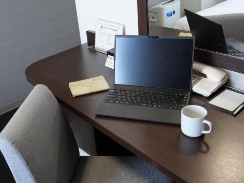 a laptop computer sitting on top of a desk at Comfort Hotel Kumamoto Shinshigai in Kumamoto