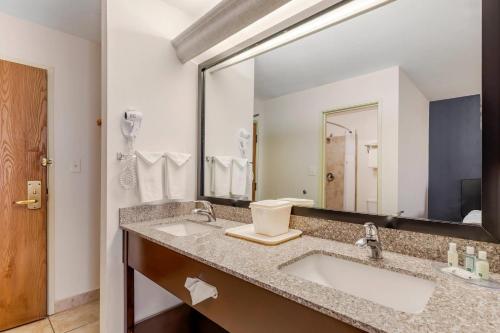 a bathroom with two sinks and a large mirror at Quality Inn & Suites Denver Airport - Gateway Park in Aurora