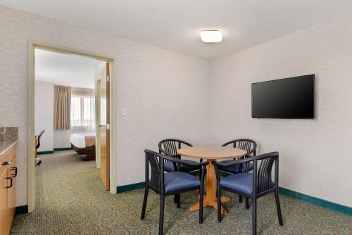 a room with a table and chairs and a television at Quality Inn & Suites Denver Airport - Gateway Park in Aurora
