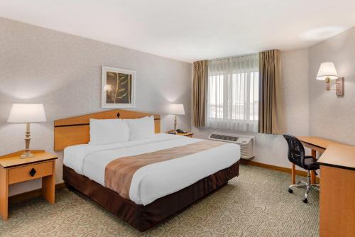 a hotel room with a large bed and a desk at Quality Inn & Suites Denver Airport - Gateway Park in Aurora