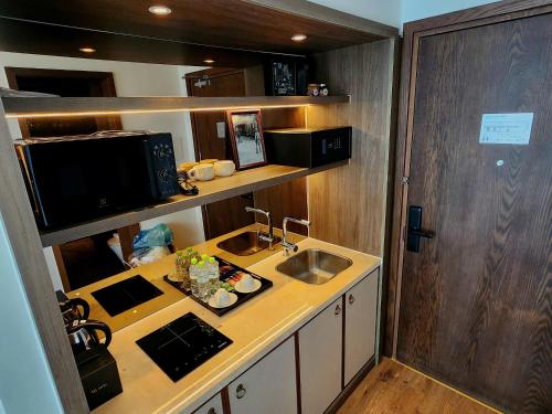 a small kitchen with a sink and a microwave at Mandala Oceanfront Driftwood Resort in Phan Thiet
