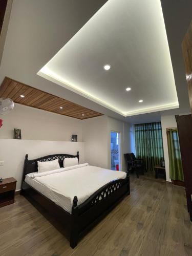 a bedroom with a large bed with a ceiling at Ramson Stay Inn in Shillong