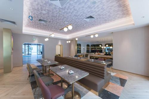 a restaurant with tables and chairs and a bar at Manxin Hotel Guangzhou Baiyun Airport Branch in Guangzhou