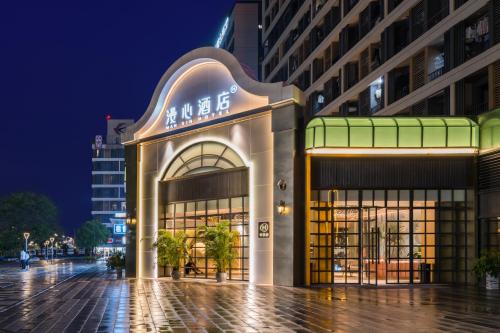 a building on a city street at night at Manxin Hotel Guangzhou Baiyun Airport Branch in Guangzhou