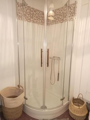 - une cabine de douche dans une salle de bains avec un panier dans l'établissement La Terrasse des Moulins Maison de Charme, à Saint-Félix-Lauragais