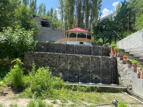 a stone retaining wall with a gazebo on top at Brookfall resort khaplu in Khaplu
