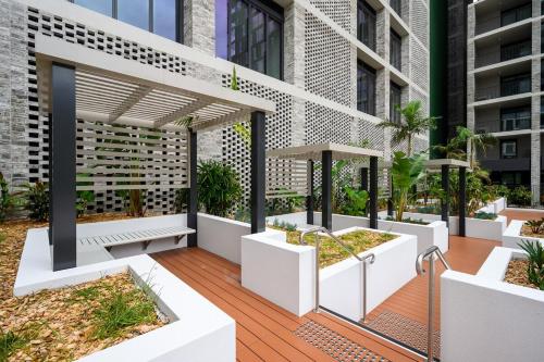 an outdoor deck with benches and plants on a building at Olympic Park 1Br modern apt near train shops with pool in Sydney