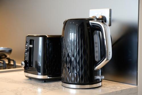 two coffeemakers sitting on a kitchen counter at Olympic Park 1Br modern apt near train shops with pool in Sydney