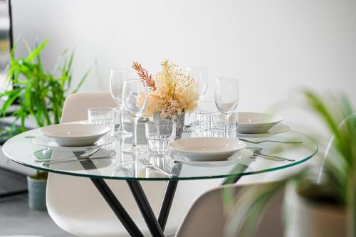 a glass table with plates and glasses on it at Olympic Park 1Br modern apt near train shops with pool in Sydney