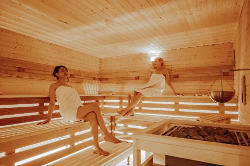two women are sitting in a sauna at Arkona Strandresidenzen in Binz