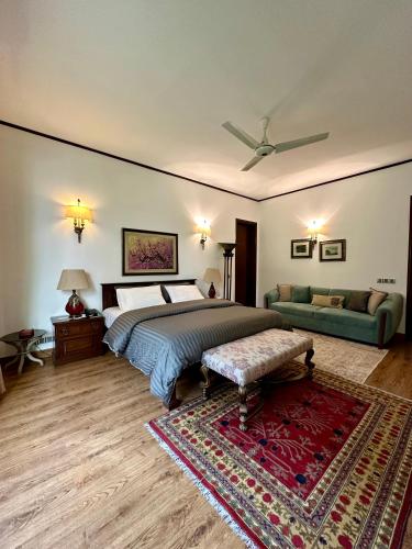 a bedroom with a bed and a couch at Elevé Villa in Karachi