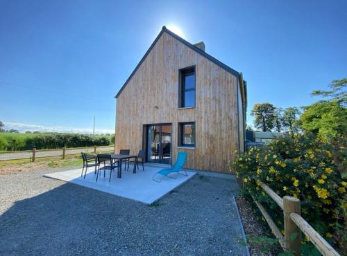 Cette maison de style grange comprend une table et des chaises. dans l'établissement Gîte de La Durantais, à Epiniac