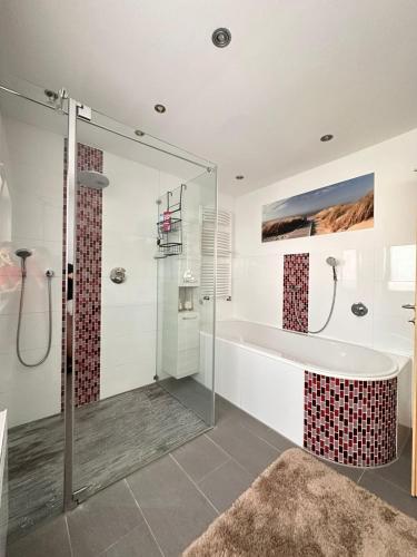 a bathroom with a tub and a glass shower at SK Apartments -Apartment mit 2 Schlafzimmern in Rust