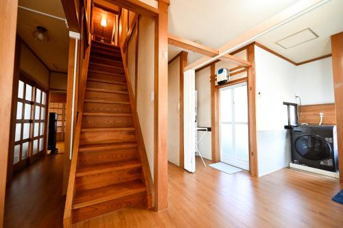 a wooden staircase in a room with a television at Oyakata Sekigahara, near the Tokugawa Ieyasu Battle of Sekigahara and Nakasendo, 8LDK, 1 building for rent in Sekigahara