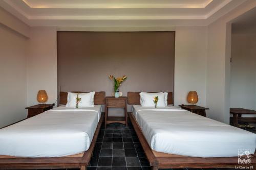 two beds in a room with two lamps at Le Clos Du Fil in Ninh Binh