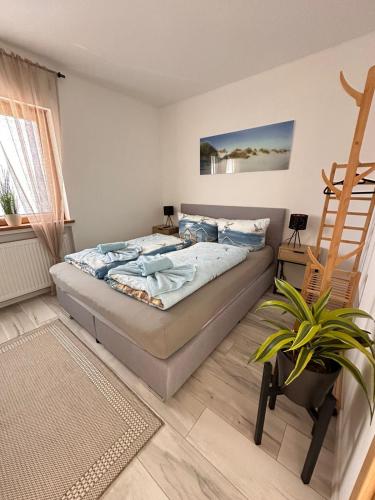a bedroom with a bed and a plant in it at SK Apartments -Apartment mit 2 Schlafzimmern in Rust