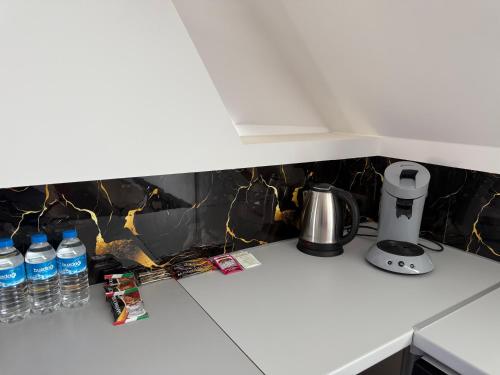 a kitchen counter with bottles of water and a coffee maker at Ferienwohnung Vierjahreszeiten Herbst in Bad Langensalza