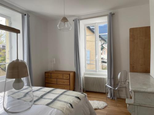 une chambre blanche avec un lit et une fenêtre dans l'établissement Superbe maison de vacances au centre d’embrun, à Embrun