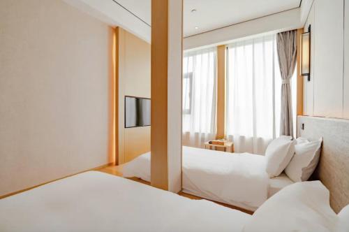 a hotel room with two beds and a window at 隐栖堂酒店 成都太古里合江亭店 in Chengdu