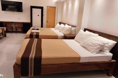 two beds in a hotel room with two beds at Hotel Lapira Vigan in Vigan