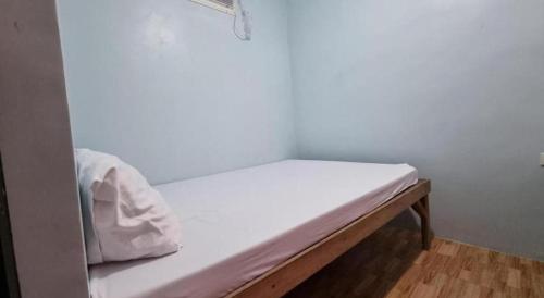 a bed in a room with a white wall at Yemaya de Laiya powered by Cocotel in Batangas City