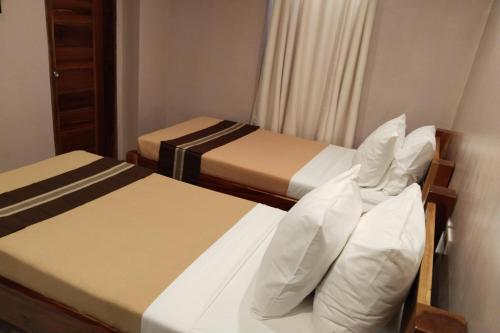 two beds in a hotel room with two beds at Hotel Lapira Vigan in Vigan