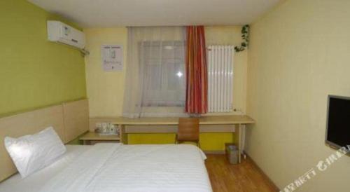 a bedroom with a bed and a desk and a window at 7 Days Inn Baoding Railway Station in Baoding