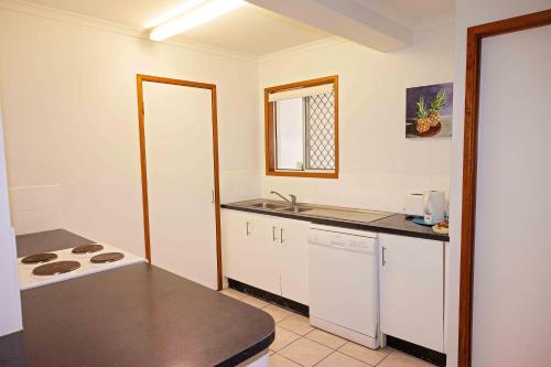 a kitchen with a stove and a counter top at The Shores Holiday Apartments in Mackay