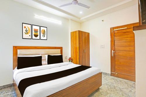 a bedroom with a large bed and a wooden door at Super Hotel O Sector 45 Formerly Manyavar in Chandīgarh