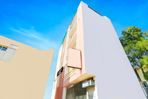 a tall white building with a blue sky in the background at Super Hotel O Sector 45 Formerly Manyavar in Chandīgarh