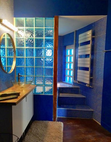 une salle de bain bleue avec un escalier et un lavabo dans l'établissement Large duplex with terrace, à Strasbourg